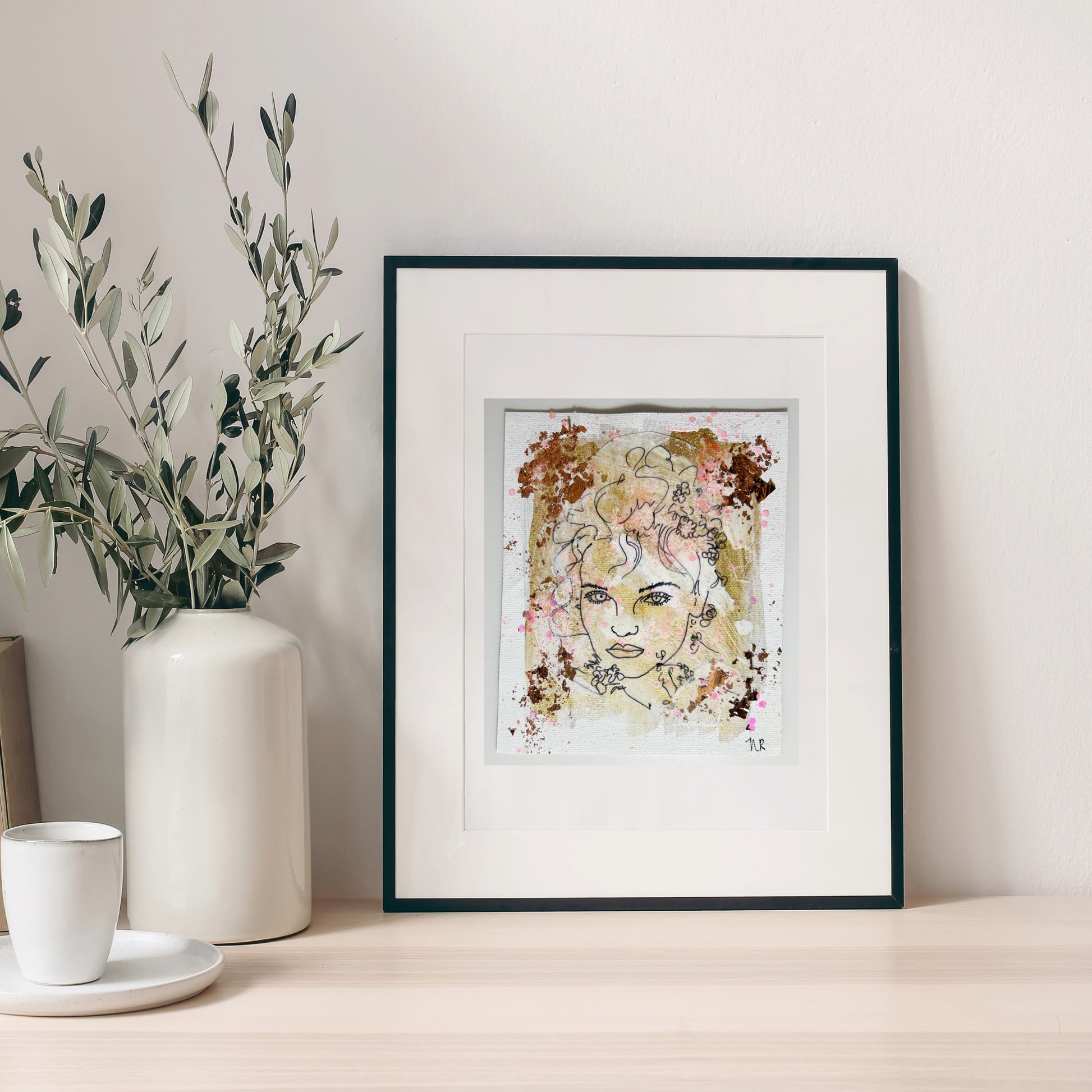 5x6 inch painting by Natalie Russo, featuring a black line drawing of a goddess with copper and gold accents, framed and displayed on a minimalist tabletop.