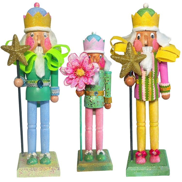 "Hand-painted glitter nutcrackers in vibrant colors, each decorated with unique designs and sparkling details. The nutcrackers are adorned with crowns, capes, and accessories, showcasing a festive and whimsical style.
